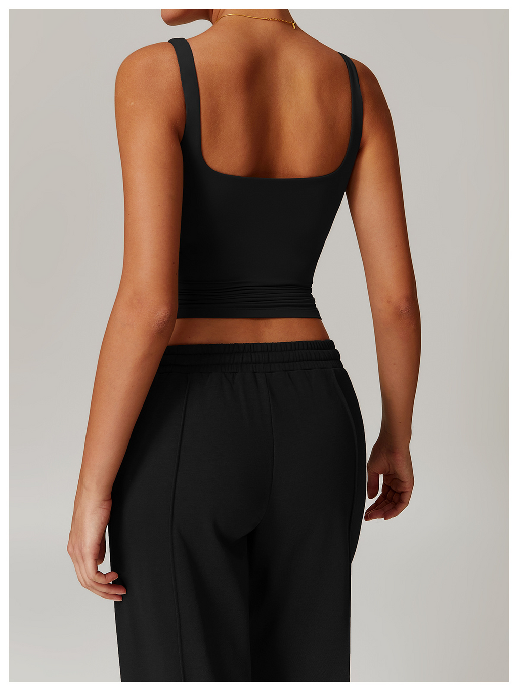 Model wearing a black top, back view.