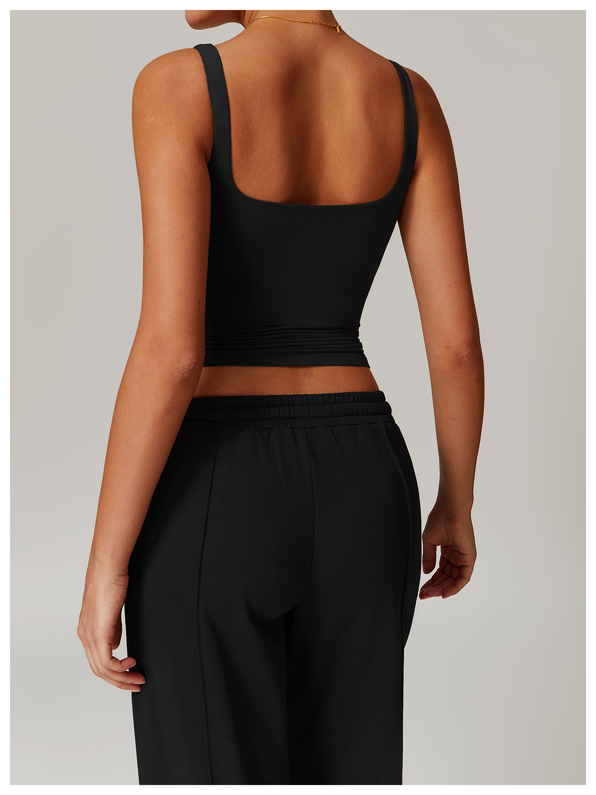 Model wearing a black top, back view.